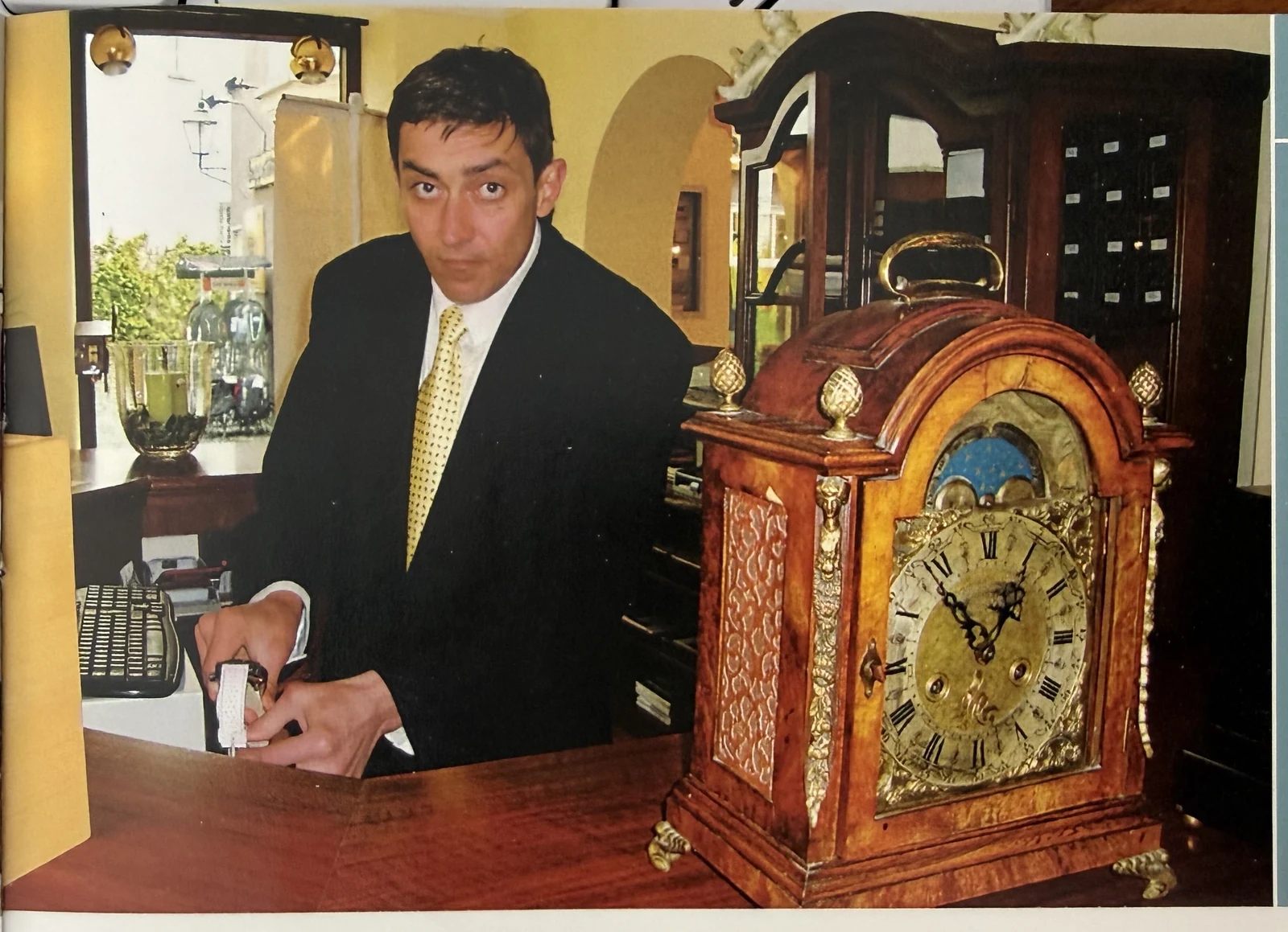 Eduard Weinbender im Atelier, an der Werkbank mit einer antiken Bracket Clock (Pariser Pendule) im Vordergrund